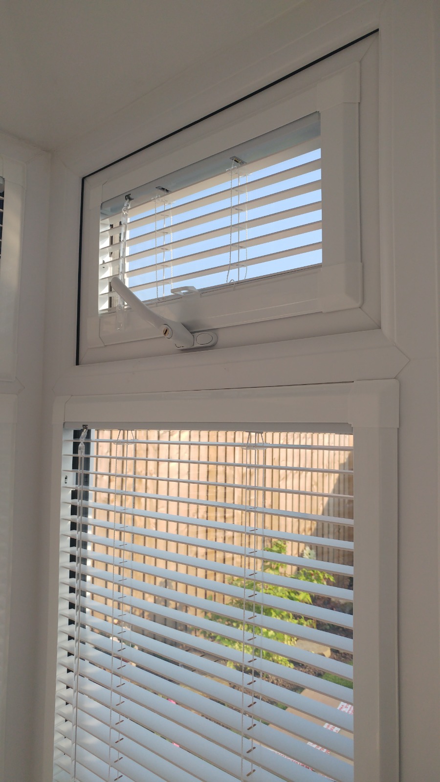 White Venetian Perfect Fit blinds on a uPVC window with an opening top light