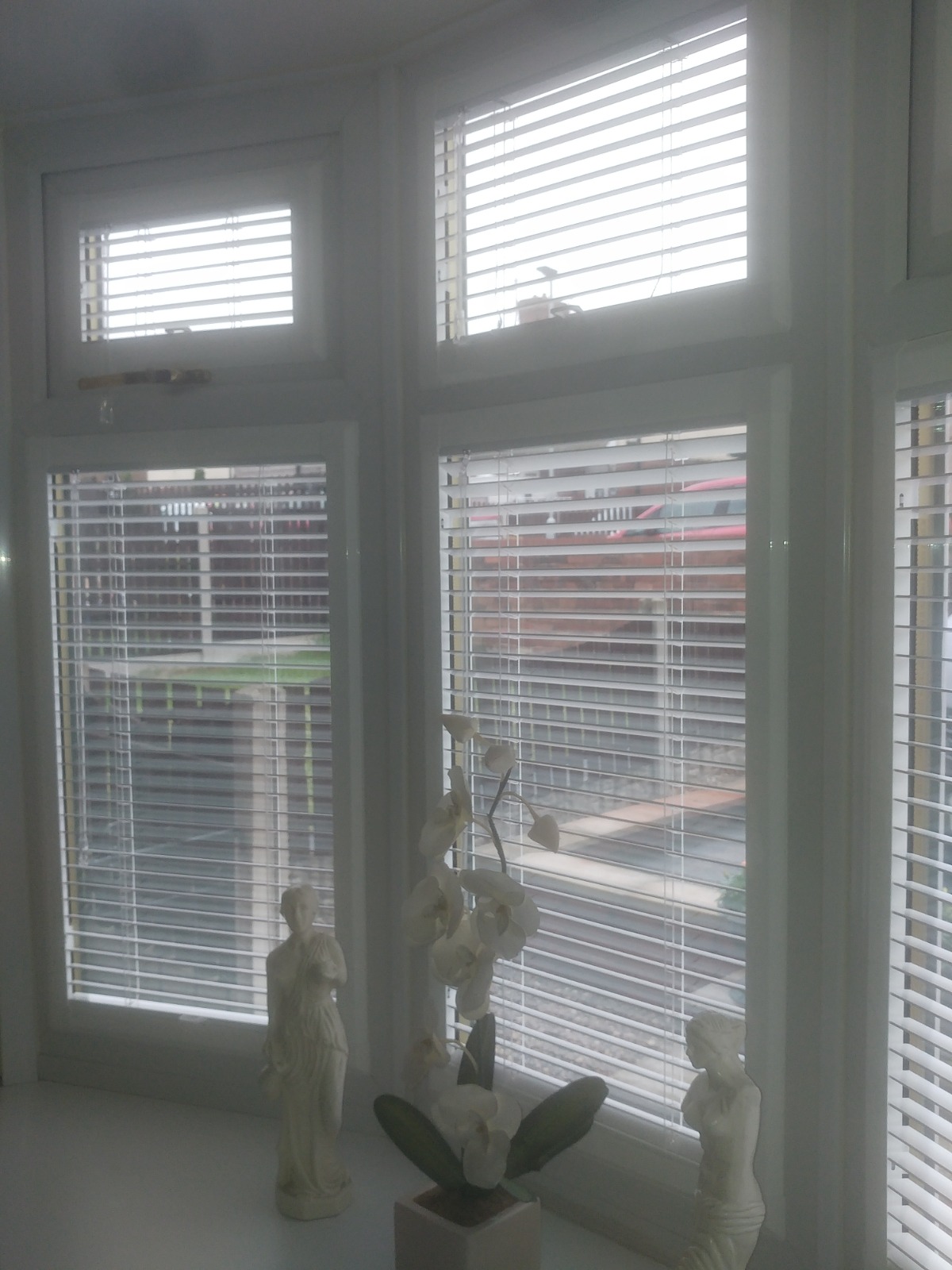 White Venetian Perfect Fit blinds within uPVC bay window frames